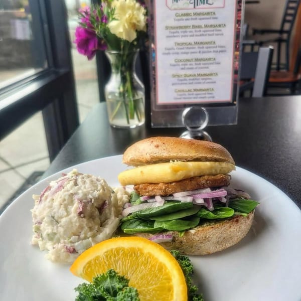 Bruchelle's Bagel Bistro's bagel sandwich with egg, spinach, red onion, and potato salad.